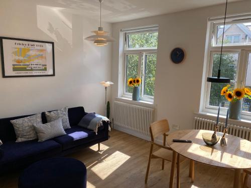 a living room with a blue couch and a table at The Studio in Frinton-on-Sea