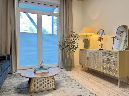 a living room with a table in front of a window at Apartment Perlmutt mit Balkon in Husum
