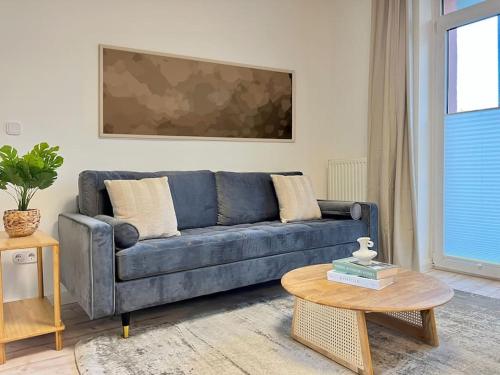 a blue couch in a living room with a table at Apartment Perlmutt mit Balkon in Husum