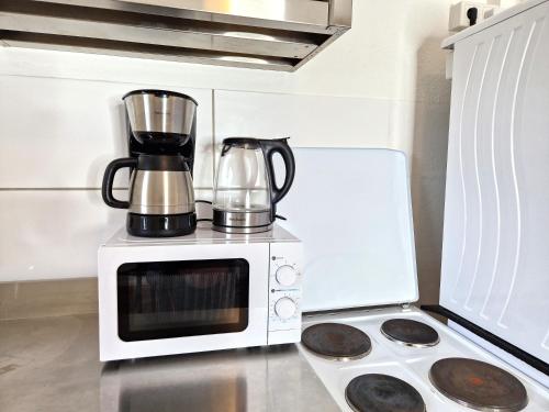 a microwave oven with a coffee maker on top of it at Meribu F85-87 Wohnung für Monteure und Arbeiter in Gelsenkirchen