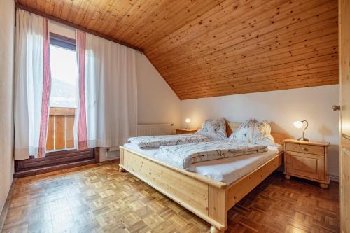 a bedroom with a large bed and a wooden ceiling at Lissis Bauernhof Appartments in Gundersheim
