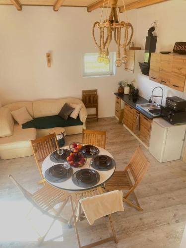 a kitchen and living room with a table and chairs at KURNIK - Domek pod lasem in Sztabin