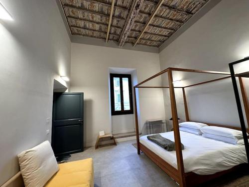 Un dormitorio con una cama con dosel y un sofá. en Nel cuore di Ronciglione, 36 Corso Umberto, en Ronciglione