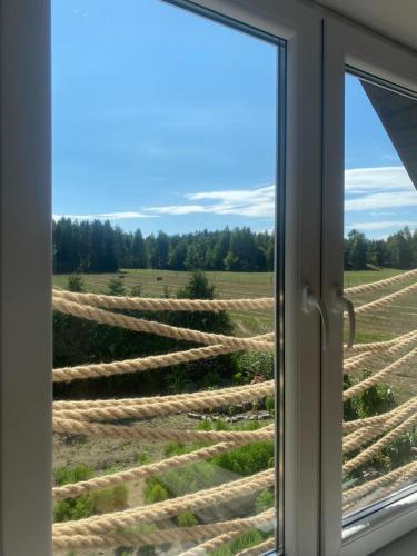 a window looking out at a field of hay at KURNIK - Domek pod lasem in Sztabin