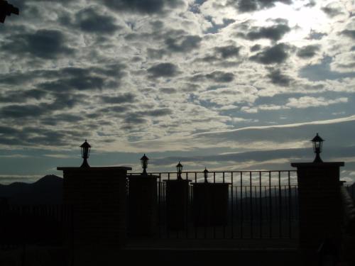 a fence with a cloudy sky in the background at Masia de la Serra de la Cogulla in Peñarroya de Tastavins