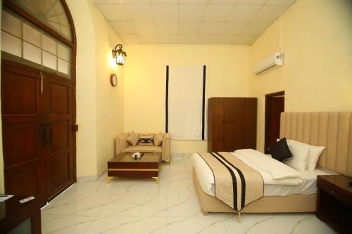 a bedroom with a bed and a chair in it at Peshawar Barracks Hotel Estb-1867 in Peshawar