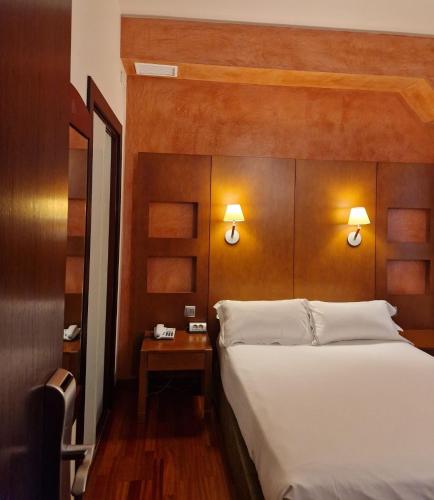 a bedroom with a large bed and a wooden headboard at Hotel Maroa Vigo in Vigo