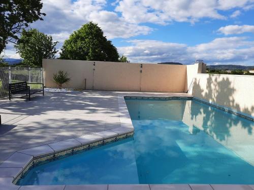 une piscine avec de l'eau bleue dans une cour arrière dans l'établissement Le Mas de la Chadeniere, à Villeuneuve-de-Berg