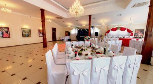 a banquet hall with white tables and white chairs at Europe in Solonka