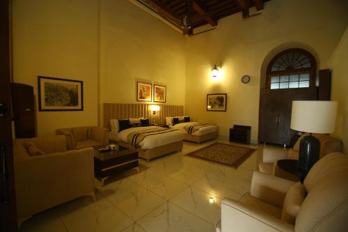a large living room with couches and a bed at Peshawar Barracks Hotel Estb-1867 in Peshawar