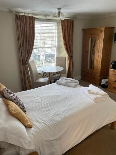 a large white bed in a room with a window at Tal Y Don Hotel in Barmouth
