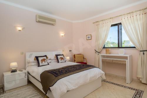 una camera con letto, scrivania e finestra di Casa Prazeres a Carvoeiro