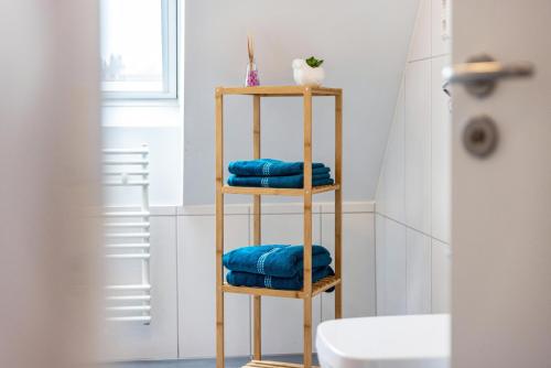 a wooden towel rack in a bathroom with blue towels at Hohenzollern in Gammertingen