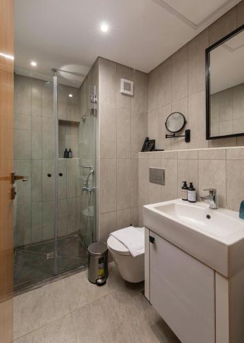 a bathroom with a shower and a toilet and a sink at Creek Hotel and Residences El Gouna in Hurghada
