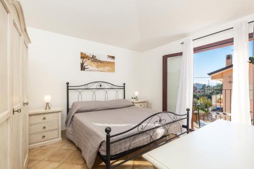 a bedroom with a bed and a balcony at ByNos Pool - Primo Piano in Santa Maria Navarrese