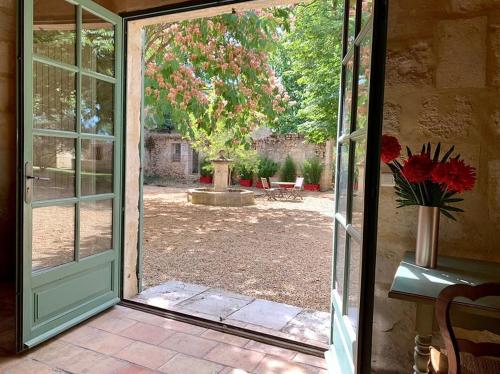 an open door to a yard with a vase of flowers at Domaine Arbaud in Redessan