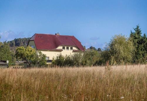a house with a red roof in a field at Haus Silbermöwe in Mariendorf