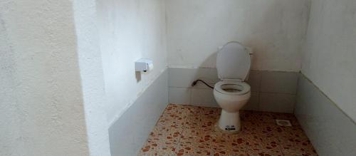 a small bathroom with a toilet in a stall at Ruhija Gorilla Guest House in Kabale