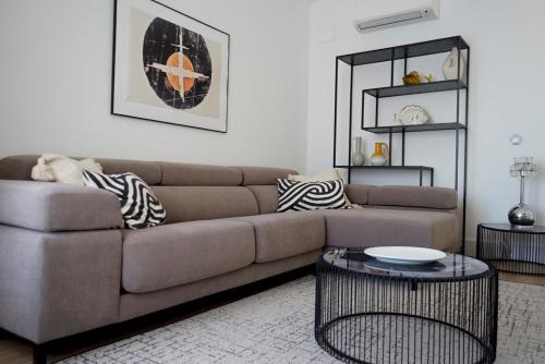 ein Wohnzimmer mit einem Sofa und einem Tisch in der Unterkunft Diaphanous and modern- 2Bd 2Bth- Plaza España in Madrid