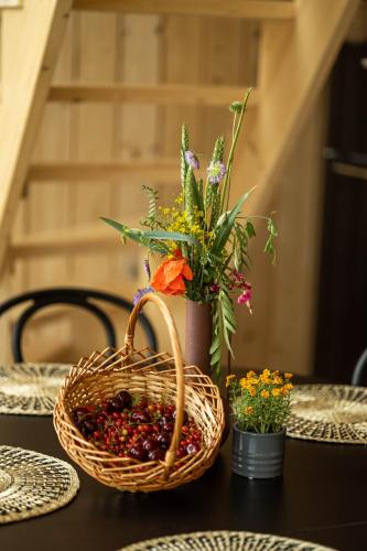 a basket of fruit and flowers on a table at Czereśniowe Wzgórze Sandomierz jakuzzi in Sandomierz