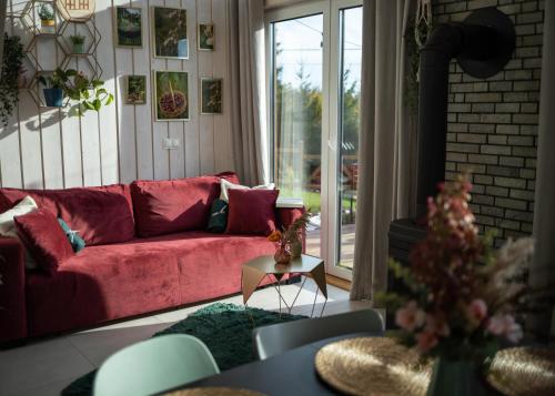 a living room with a red couch in front of a window at Czereśniowe Wzgórze Sandomierz jakuzzi in Sandomierz