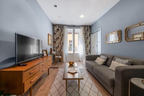 ein Wohnzimmer mit einem Sofa und einem Flachbild-TV in der Unterkunft 1 bedroom 1 bathroom furnished - Sol - Downtown - Minty Stay in Madrid