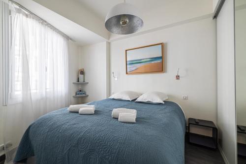 um quarto com uma cama azul com duas toalhas em Bel appartement 3P Croisette*Cannes em Cannes