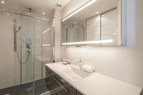 La salle de bains blanche est pourvue d'un lavabo et d'une douche. dans l'établissement Bel appartement 3P Croisette*Cannes, à Cannes