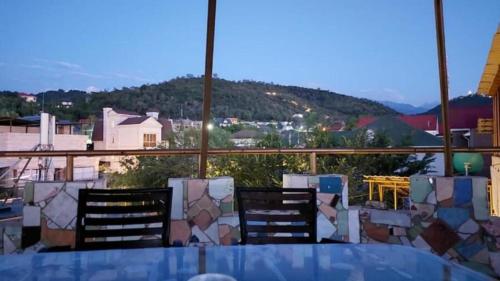 d'une table et de chaises sur un balcon avec vue. dans l'établissement Assem Hostel Koktobe, à Almaty