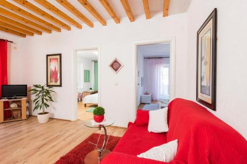 sala de estar con sofá rojo y mesa en Sunset house with seaview en Hvar