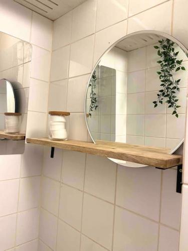 a mirror on a shelf in a bathroom at Cozy studio in the heart of Kallio next to metro in Helsinki