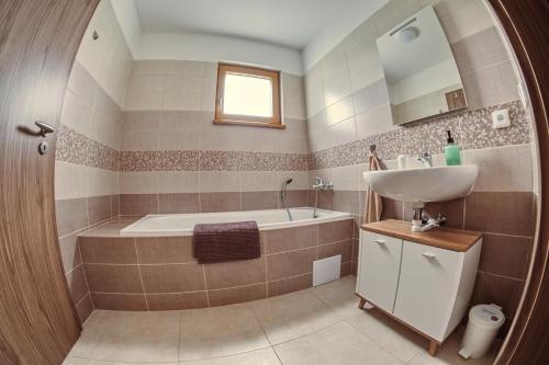 a bathroom with a tub and a sink at Chata pod Jasanem in Dolní Morava