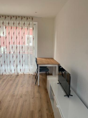 a room with a desk and a tv and a window at Wohnung in Betzingen in Reutlingen