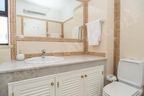 y baño con lavabo, aseo y espejo. en Pampas Altogolfe 2 Bedroom Apartment, en Portimão