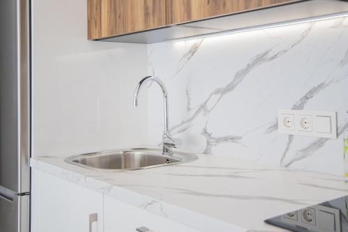 a kitchen with a sink in a white counter top at Cubo's Apartamento Perla del Sol 3I in Torremolinos