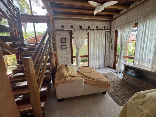 sala de estar con escalera, sofá y ventanas en Casa com Piscina, Barra do Una., en São Sebastião