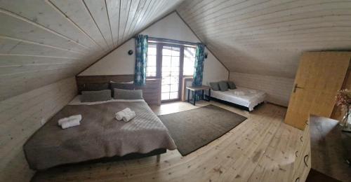 a bedroom with a large bed in a attic at Piligrimo sodyba in Kadarės