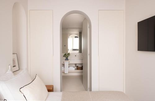 Habitación blanca con cama y espejo en The Onsider - Luxury Apartment with 3 bedrooms and 2 private patios, en Barcelona