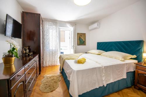 - une chambre avec un grand lit et une télévision dans l'établissement Apartments Filipeti, à Makarska
