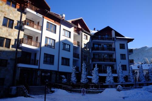 a large building with christmas trees in front of it at Your Place Borovets in Borovets