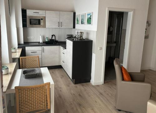 eine Küche mit einem Tisch und Stühlen im Zimmer in der Unterkunft Gästehaus Mietz in Bad Neuenahr-Ahrweiler