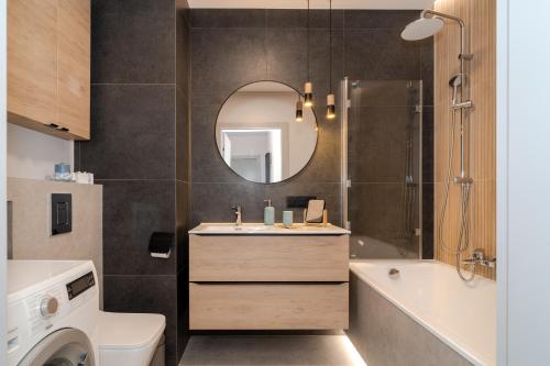 a bathroom with a sink and a toilet and a mirror at TOTU HOME Perspektywa Apartament Gdańsk Centrum in Gdańsk