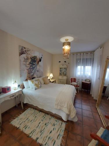 a bedroom with a large white bed with a rug at Un mar de pinares 