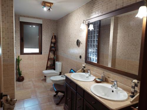 a bathroom with two sinks and a toilet at Un mar de pinares 