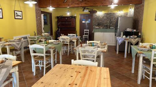 a dining room with tables and white chairs at La corte dell'ulivo in Polazzo