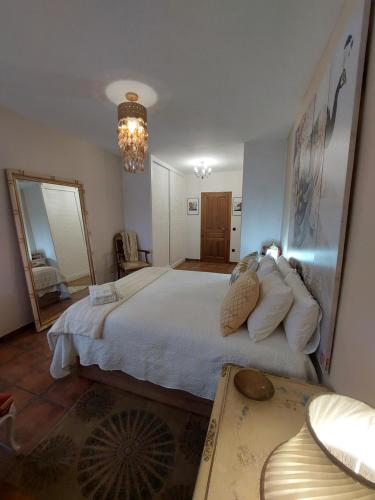 a bedroom with a large white bed and a mirror at Un mar de pinares in Mata de Cuéllar