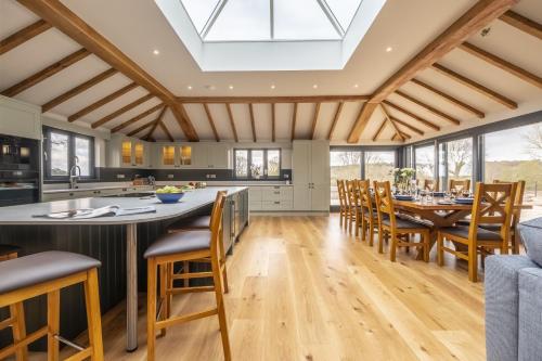 an open kitchen and dining room with a skylight at Wild Meadow Barn in Aylsham