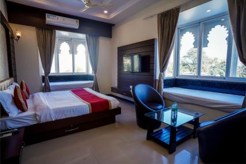 - une chambre avec deux lits, une chaise et une table dans l'établissement Tiger's Trail Hotel & Food Court, à Kumbhalgarh