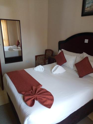 a bedroom with a bed with a red bow on it at Okavango Roadside Guesthouse in Maun