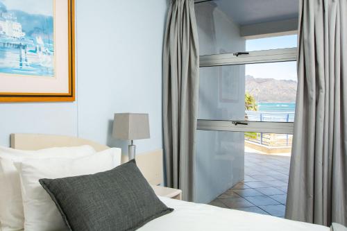 a bedroom with a bed and a view of the ocean at False Bay Inn in Strand